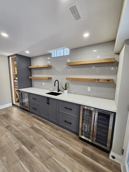Basement finishing in East Gwillimbury: the bar counter, the beverage fridges and the tile backsplash
