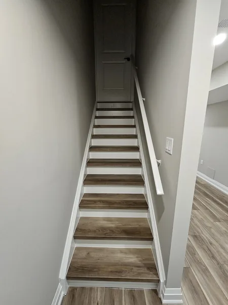 Basement stairs Toronto: treads matching the vinyl plank floor — built in East Gwillimbury